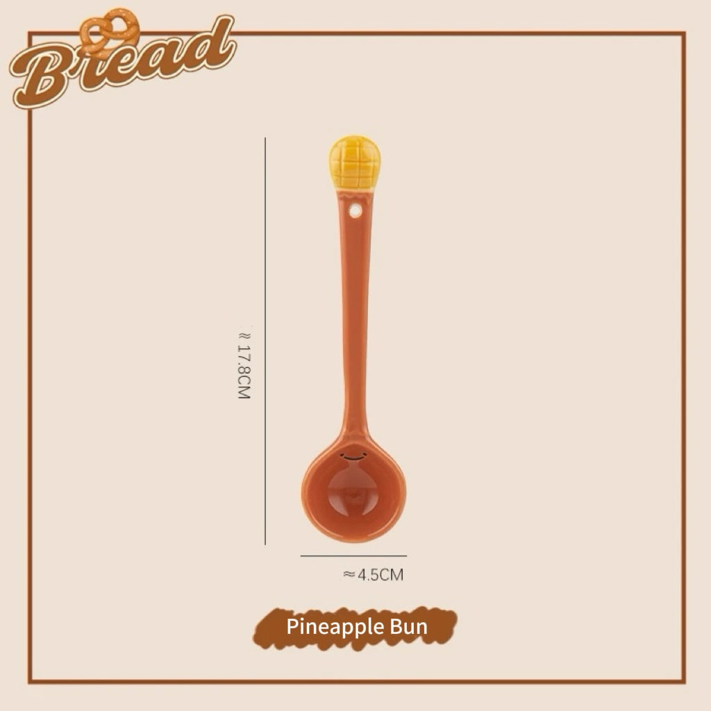 A set of ceramic measuring spoons with cute snack-themed handles, displayed in a kitchen setting.