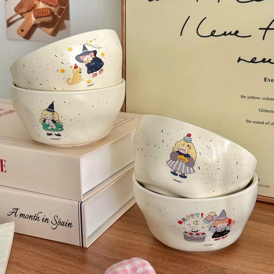Set of white bowls with cartoon character designs on a wooden surface.