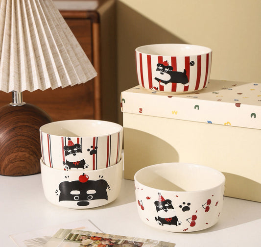 Set of ceramic bowls with dog illustrations on a table.