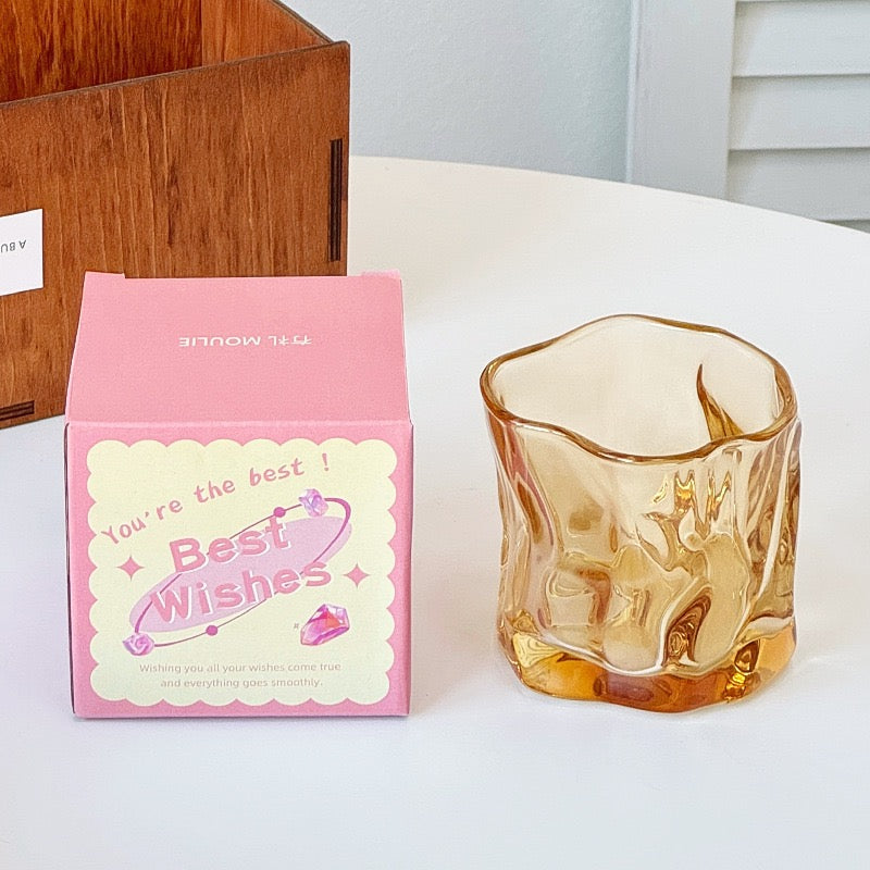 A collection of irregular glass cups with a wavy texture, displayed in various translucent colors such as pink, blue, and green, without packaging.