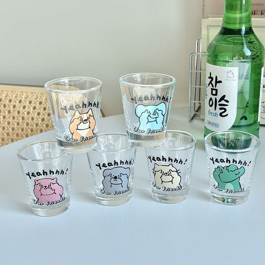 Set of six small glass shot glasses with animal illustrations and 'Yeahhh!' text, next to a bottle of Soju.