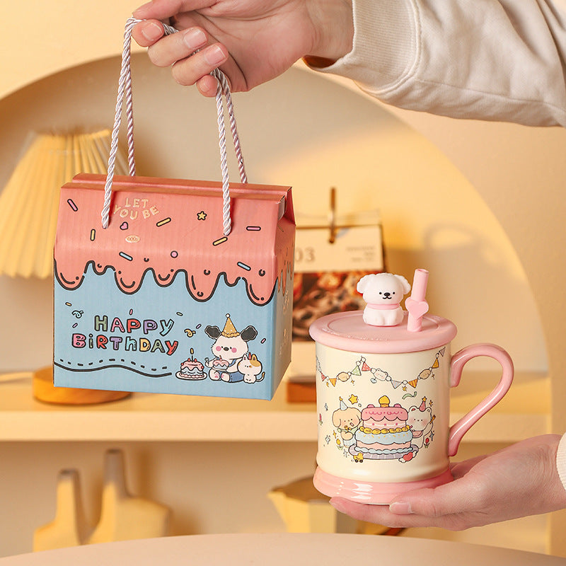 Cute mug with cartoon design and matching gift box on a soft background