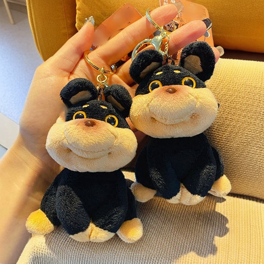 Two plush monkey keychains held by a hand on a textured surface.