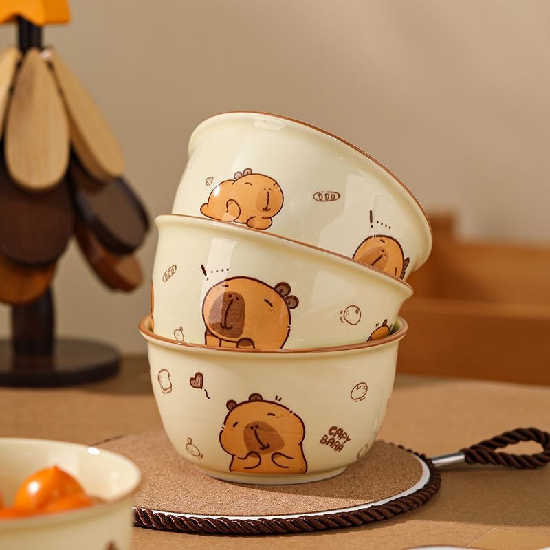 Set of three cartoon bear bowls stacked on a table with a blurred background