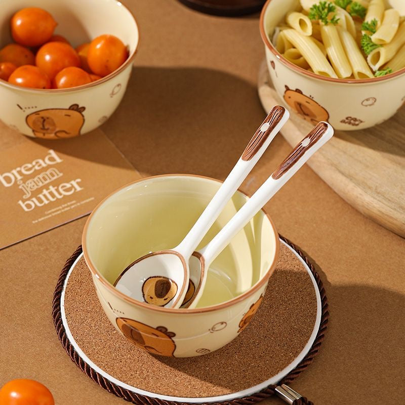 Cute ceramic bowls with cartoon designs on a brown surface