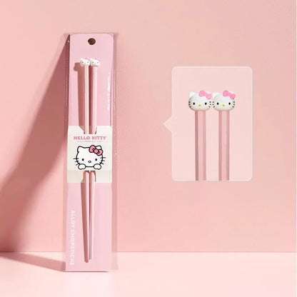 Pink Hello Kitty-themed chopsticks with packaging on a pink background