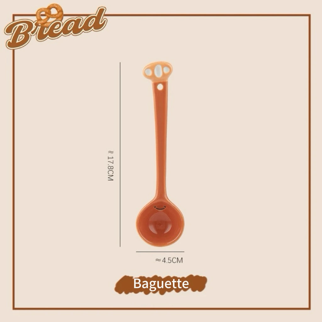 A set of ceramic measuring spoons with cute snack-themed handles, displayed in a kitchen setting.