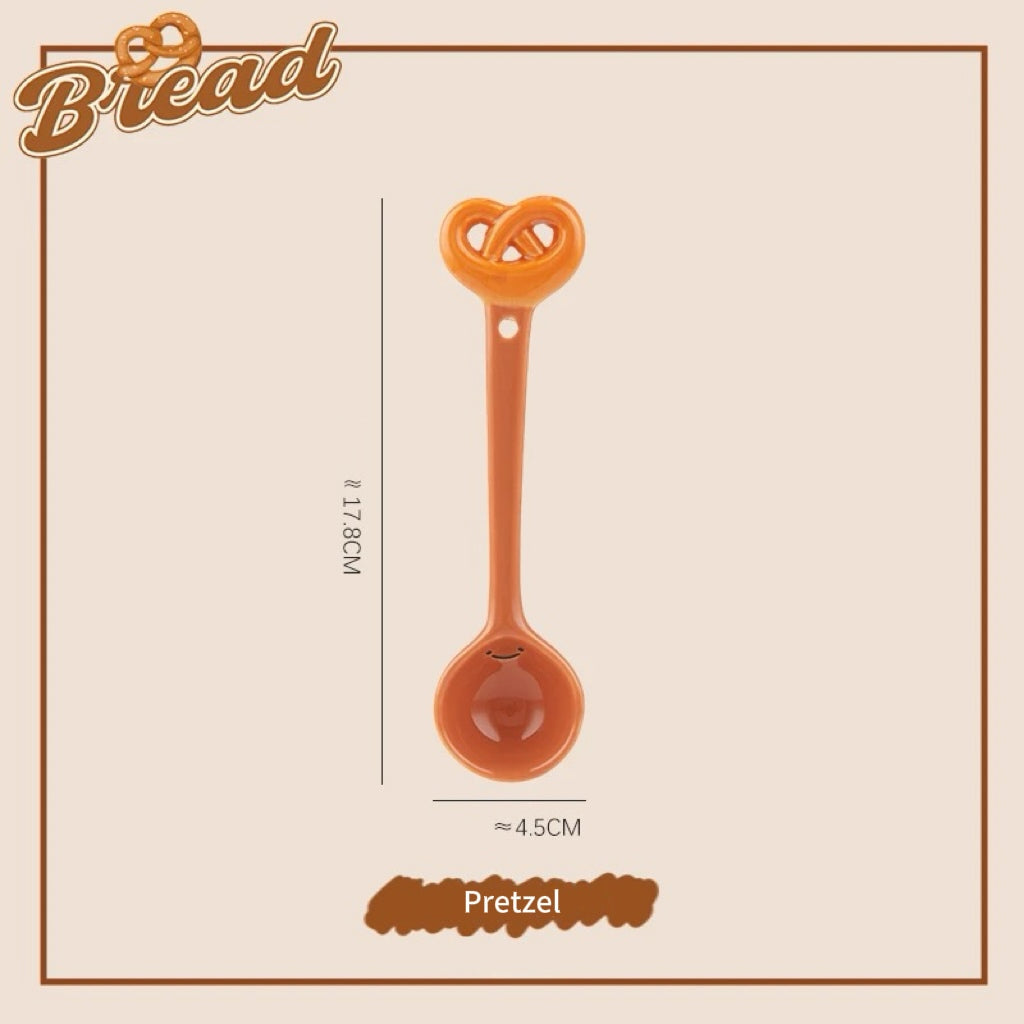 A set of ceramic measuring spoons with cute snack-themed handles, displayed in a kitchen setting.