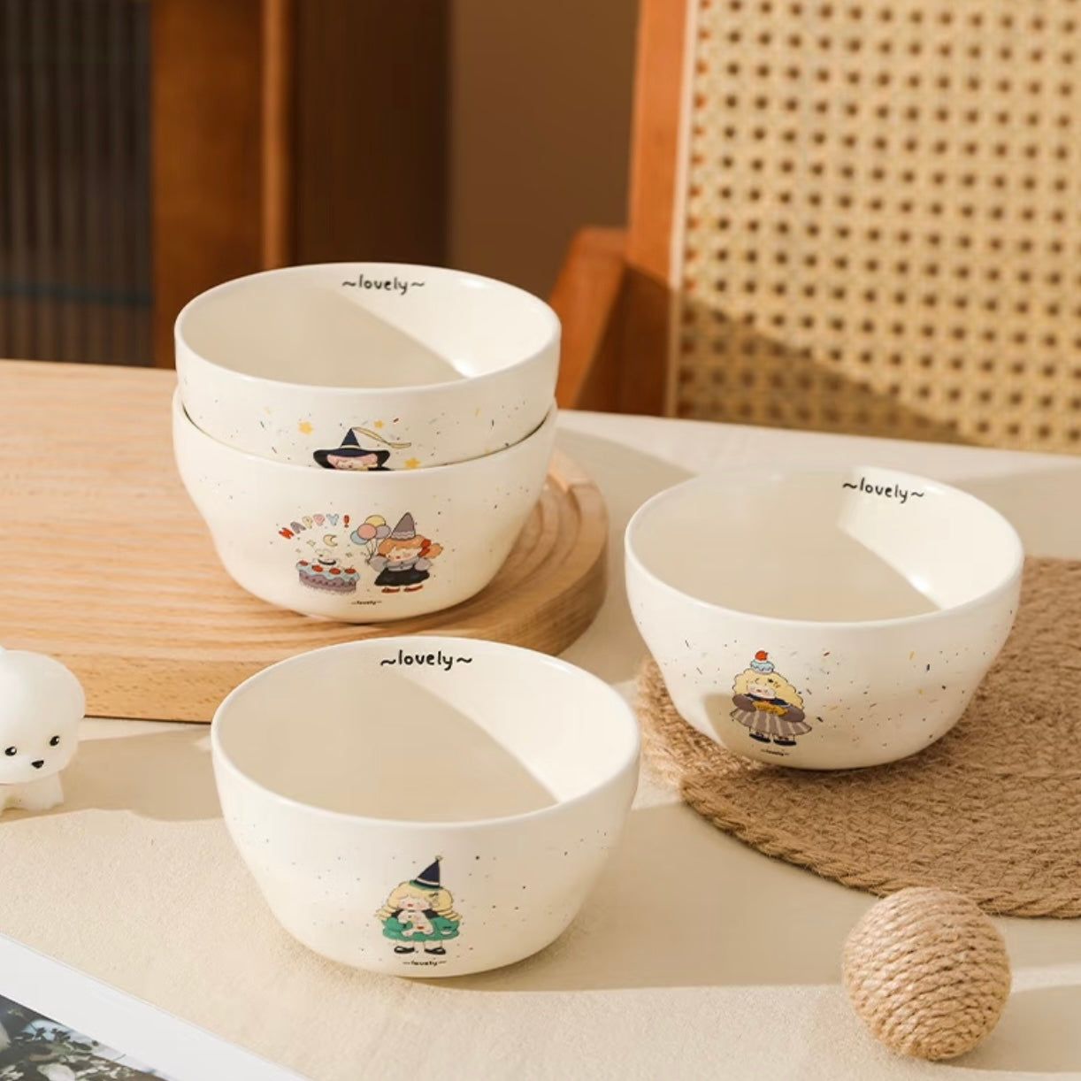 Set of ceramic bowls with cartoon designs on a wooden surface