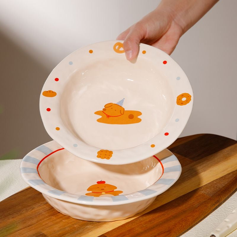 Two ceramic bowls with cartoon designs on a wooden surface