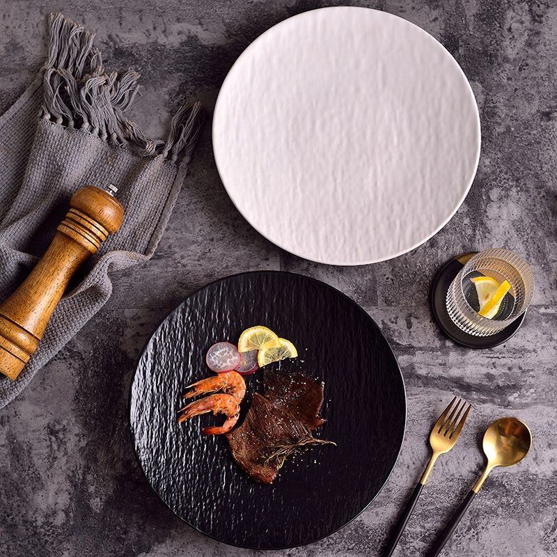 Minimalist textured ceramic dinner plate in black and white with matte finish, ideal for modern table settings.