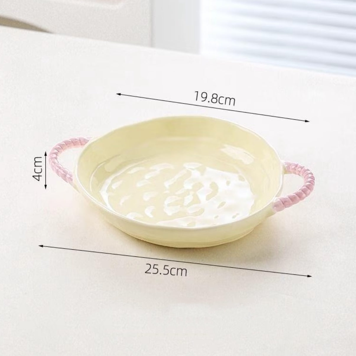 Yellow plate with pink handles and measurements on a white background