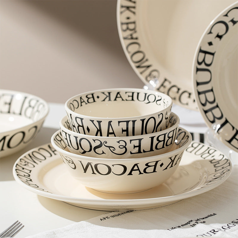 Set of ceramic bowls and plates with text design on a neutral background