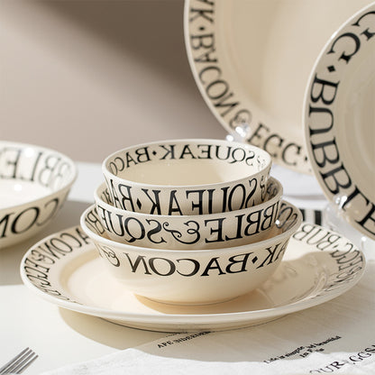 Set of ceramic bowls and plates with text design on a neutral background