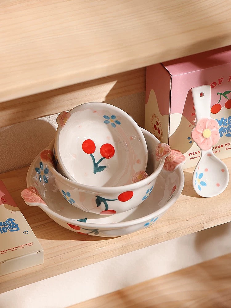 Children's ceramic tableware set with floral design on a wooden shelf