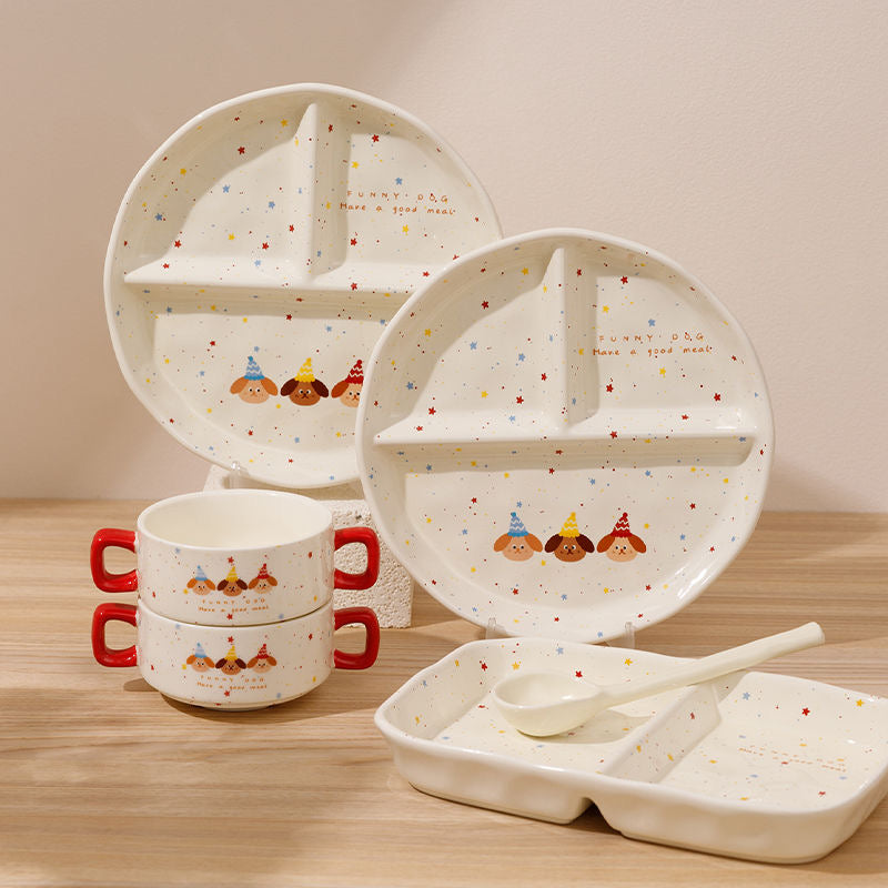 Children's ceramic dinner set with cartoon design on a wooden surface
