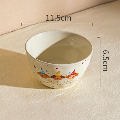 Ceramic bowl with cartoon designs on a beige surface, showing measurements.
