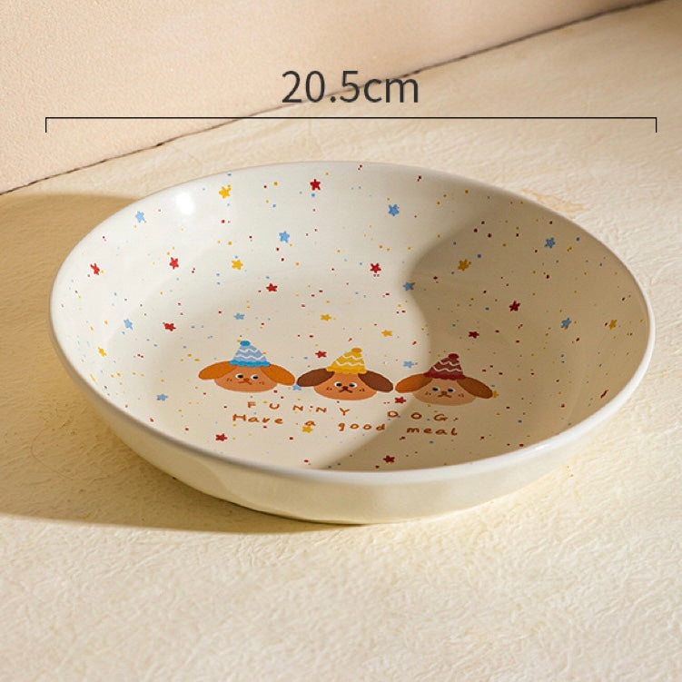 Ceramic bowl with cartoon designs and text, placed on a light surface.