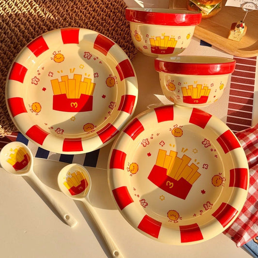 Children's dinnerware set with french fry design on a checkered tablecloth.