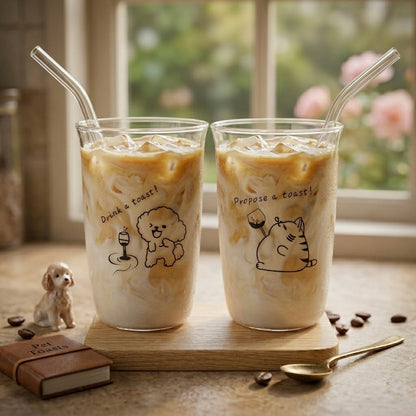 Two glasses of iced coffee with straw on a wooden coaster, featuring cute animal illustrations.