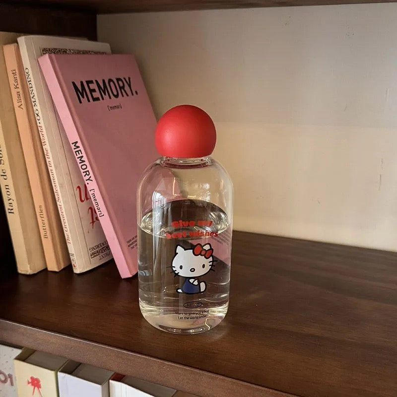 Clear bottle with red cap on a shelf next to books