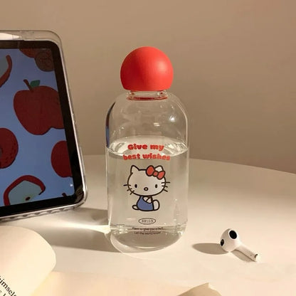 Clear bottle with red cap and Hello Kitty design next to a smartphone on a light surface.