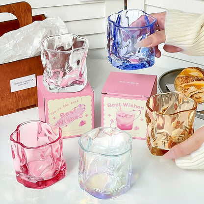 Aesthetic irregular glass cup in various colors with wavy texture, perfect for stylish drinkware.
