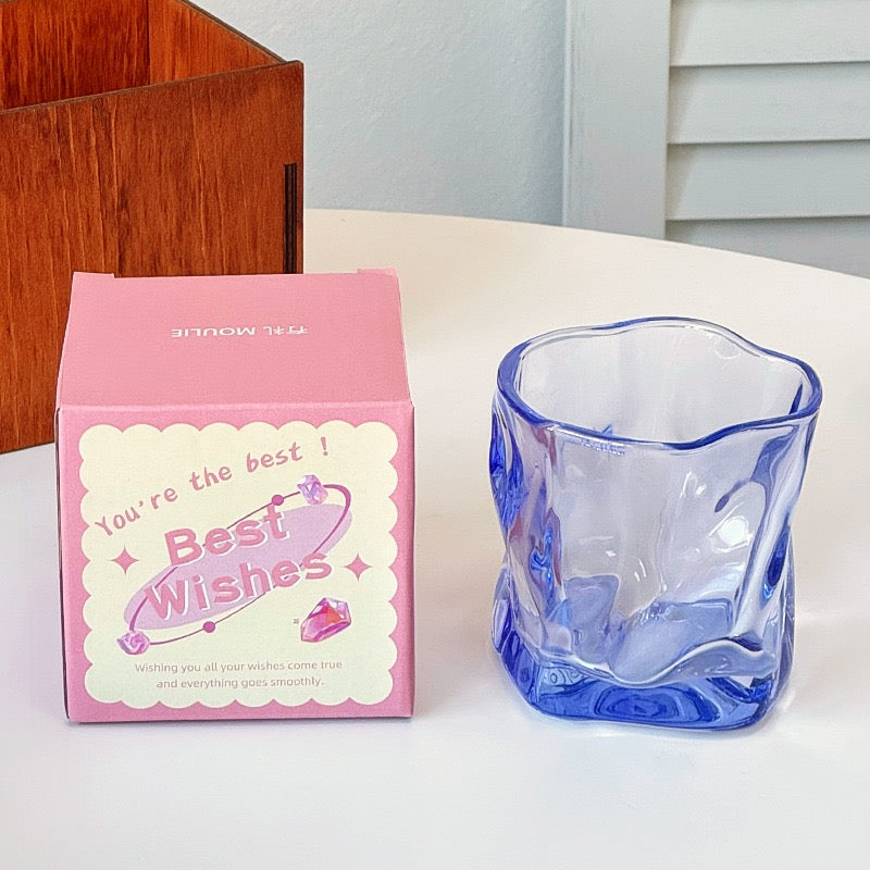 A collection of irregular glass cups with a wavy texture, displayed in various translucent colors such as pink, blue, and green, without packaging.