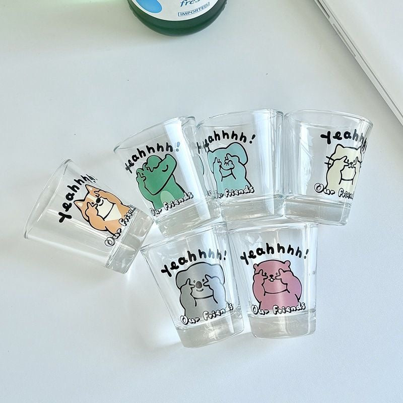 Set of clear shot glasses with cartoon animal designs and text on a white surface.