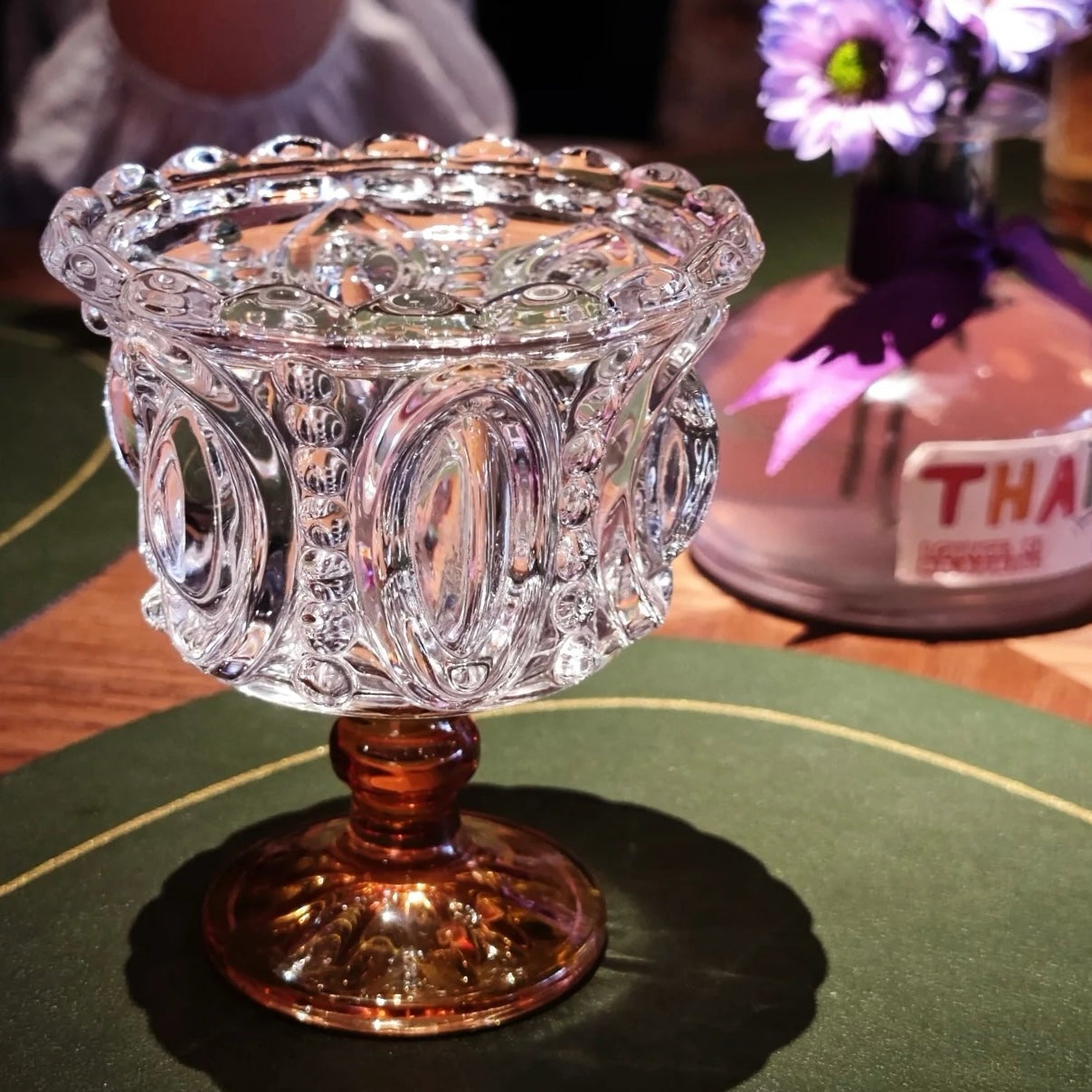 Decorative glass bowl on a green surface with a blurred background