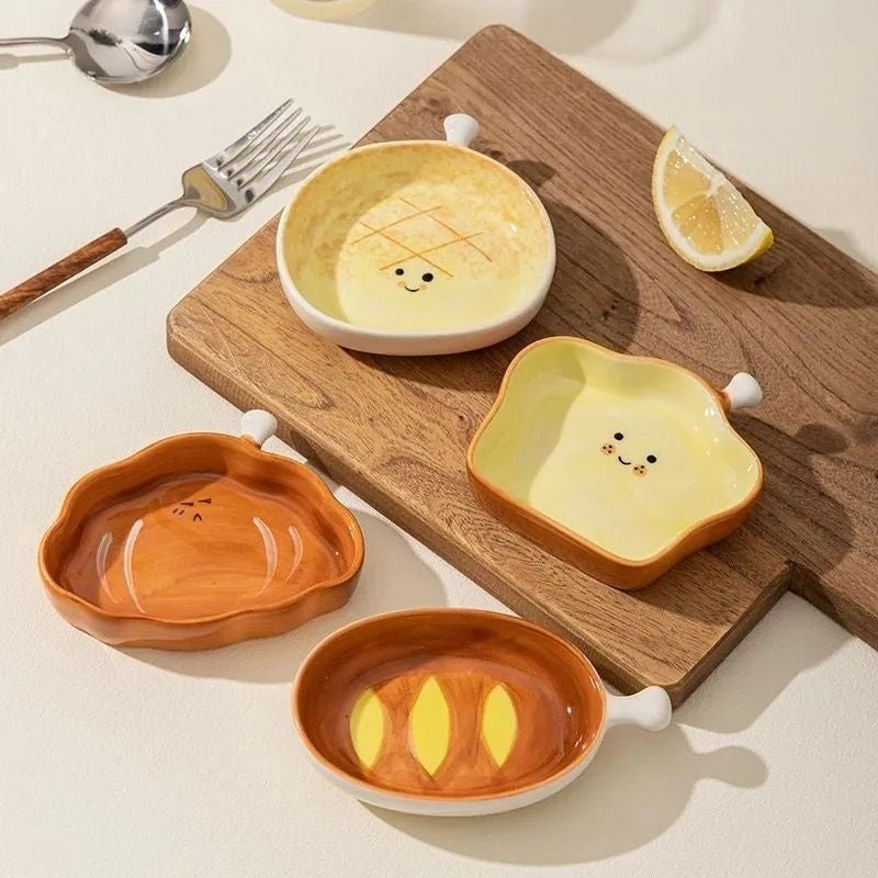 Set of four cute ceramic bowls with smiley faces on a wooden cutting board.
