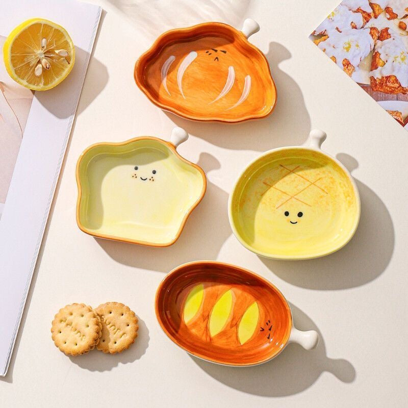 Set of colorful ceramic plates with smiley faces on a light surface.