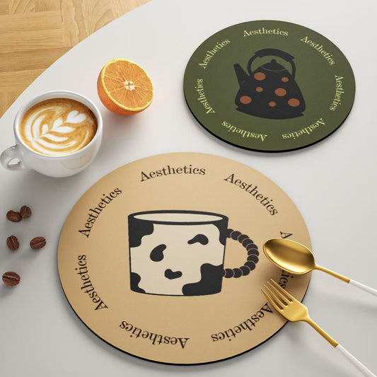 Two round coasters with coffee-themed designs on a table with a cup of coffee, orange, and utensils.