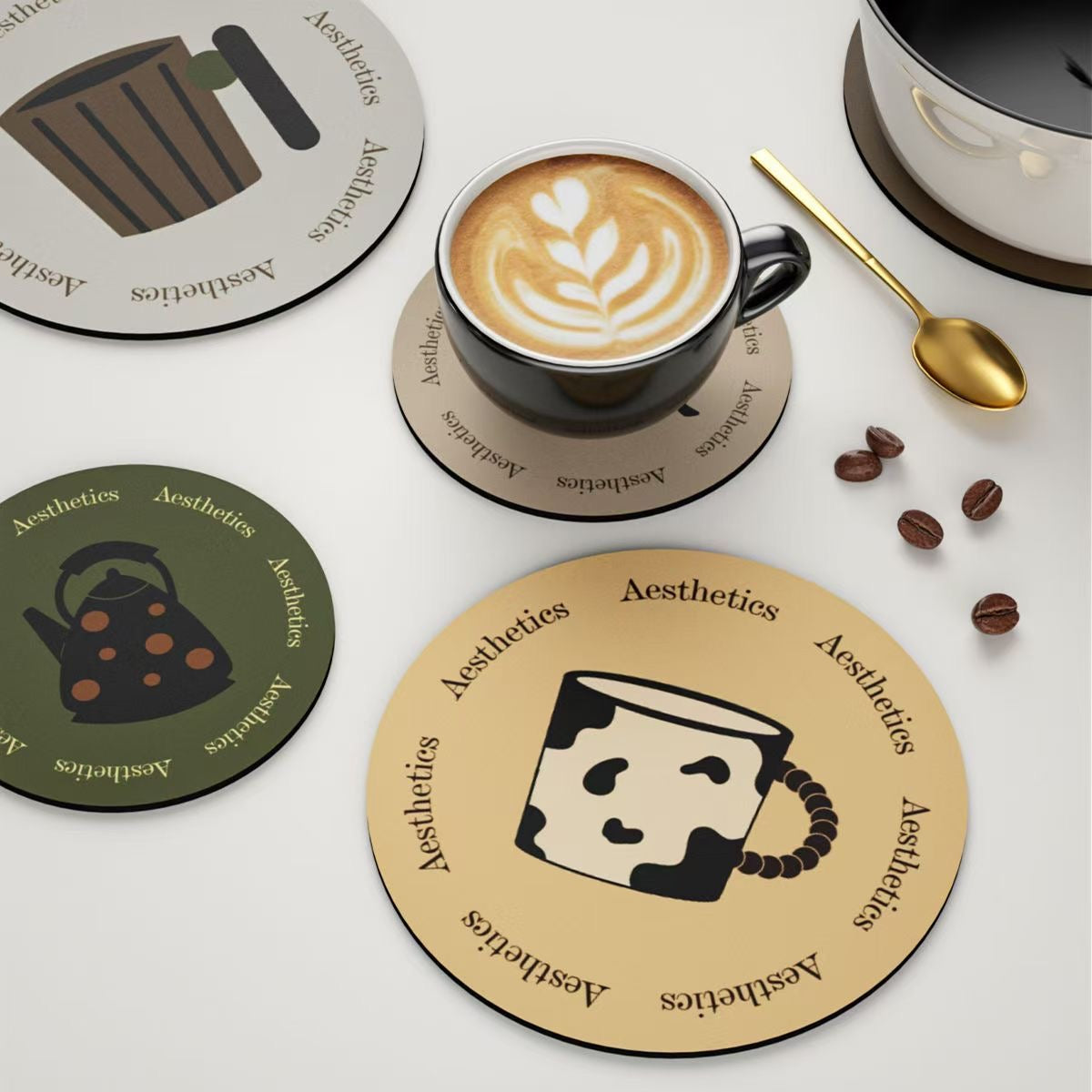 Coasters with coffee-themed designs on a white surface with a cup of coffee and beans.