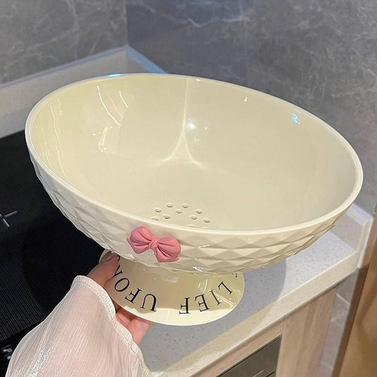 Elegant cream-colored draining bowl with pink bow detail and built-in drainage holes.