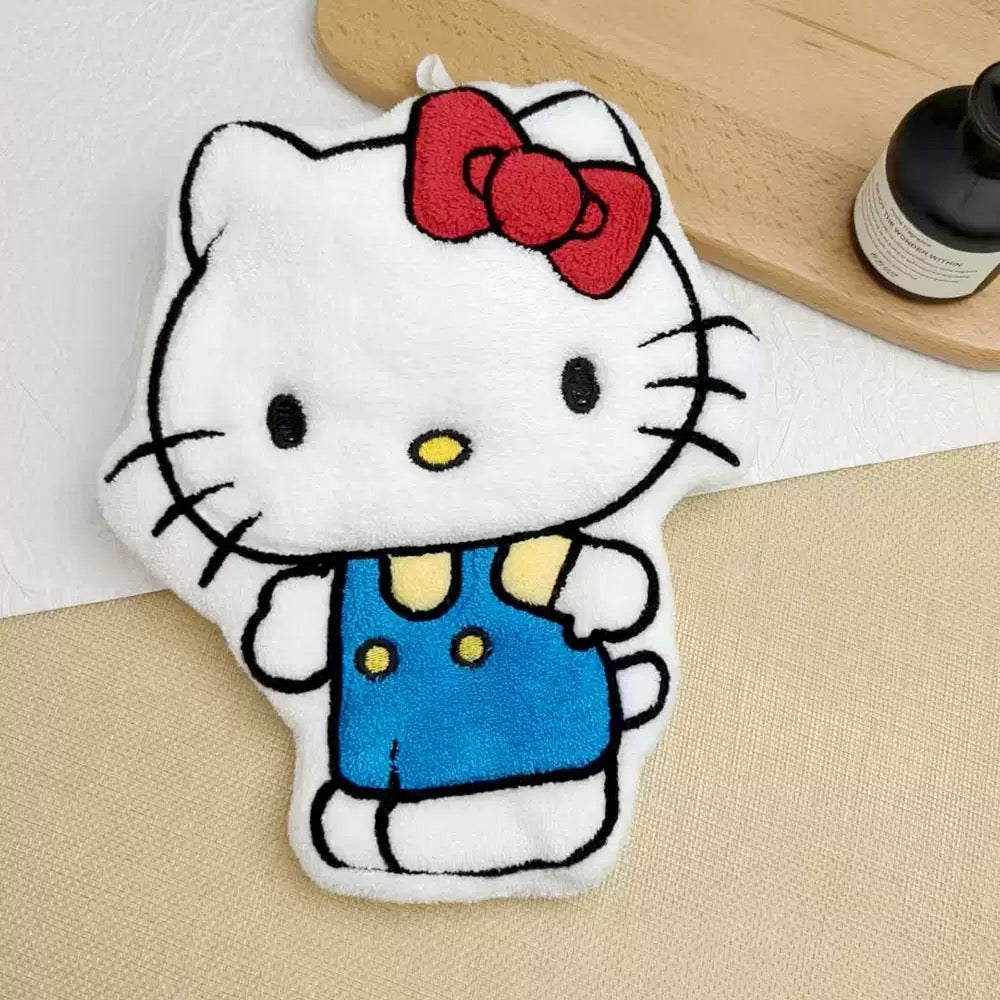 Hello Kitty plush toy with a red bow on a beige surface