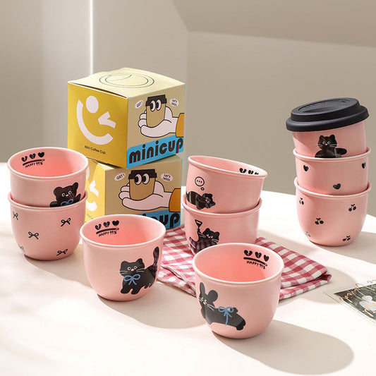 Cute pink ceramic coffee cup with black cat design, lid, and gift packaging