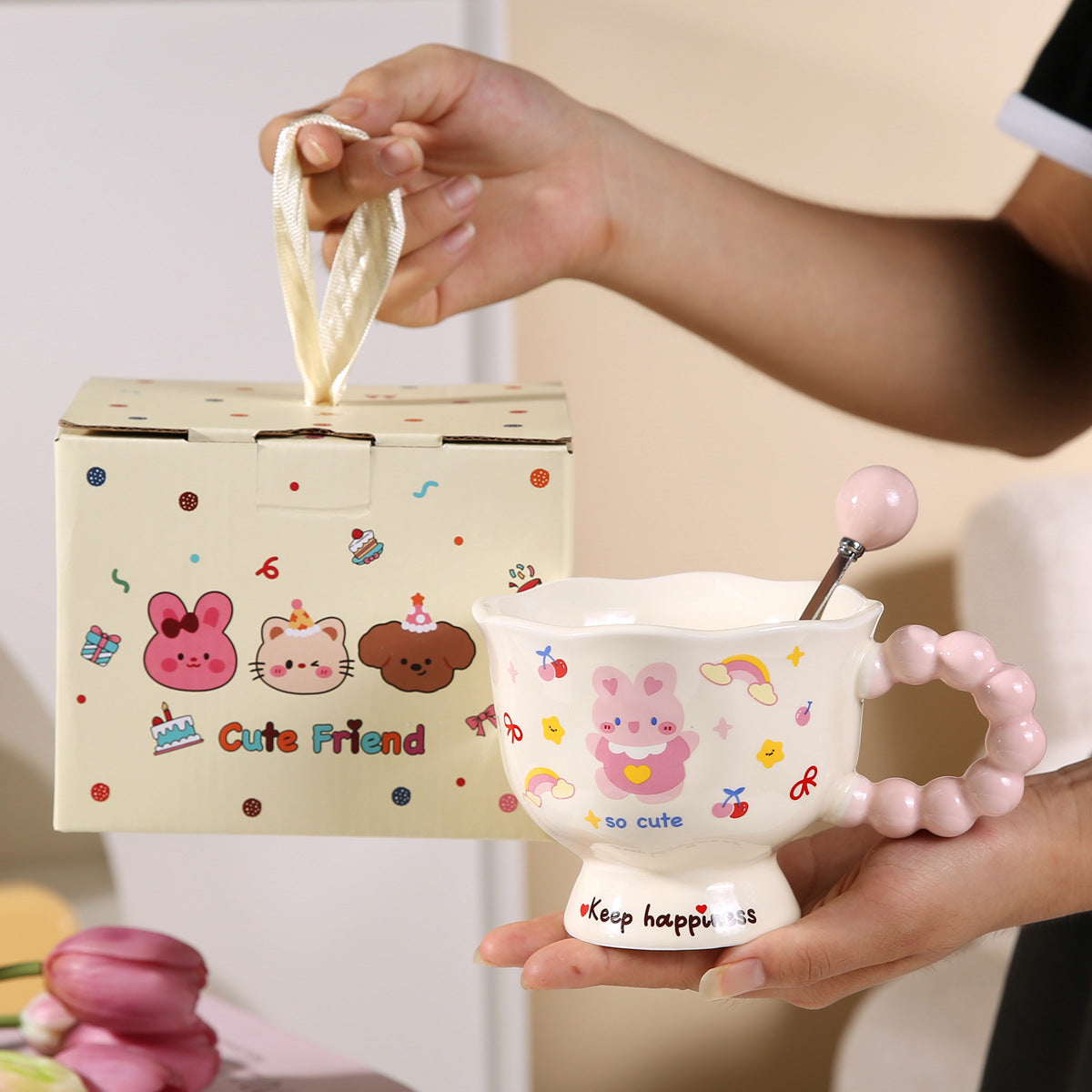Cute ceramic bowl with cartoon design held by a person, next to a matching box.