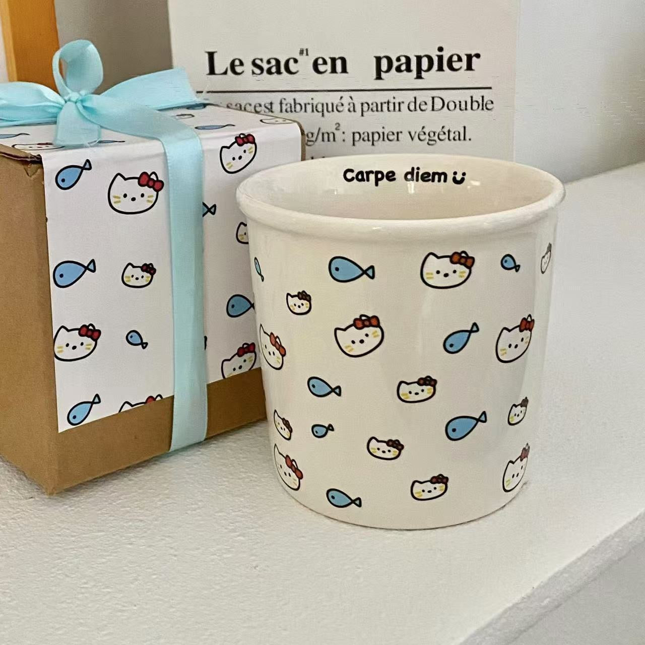 Handmade ceramic cup with colorful stars and ¡°Shine like the stars¡± text inside. / Handmade ceramic cup with kitty and fish pattern, featuring ¡°Carpe diem ?¡± inside.