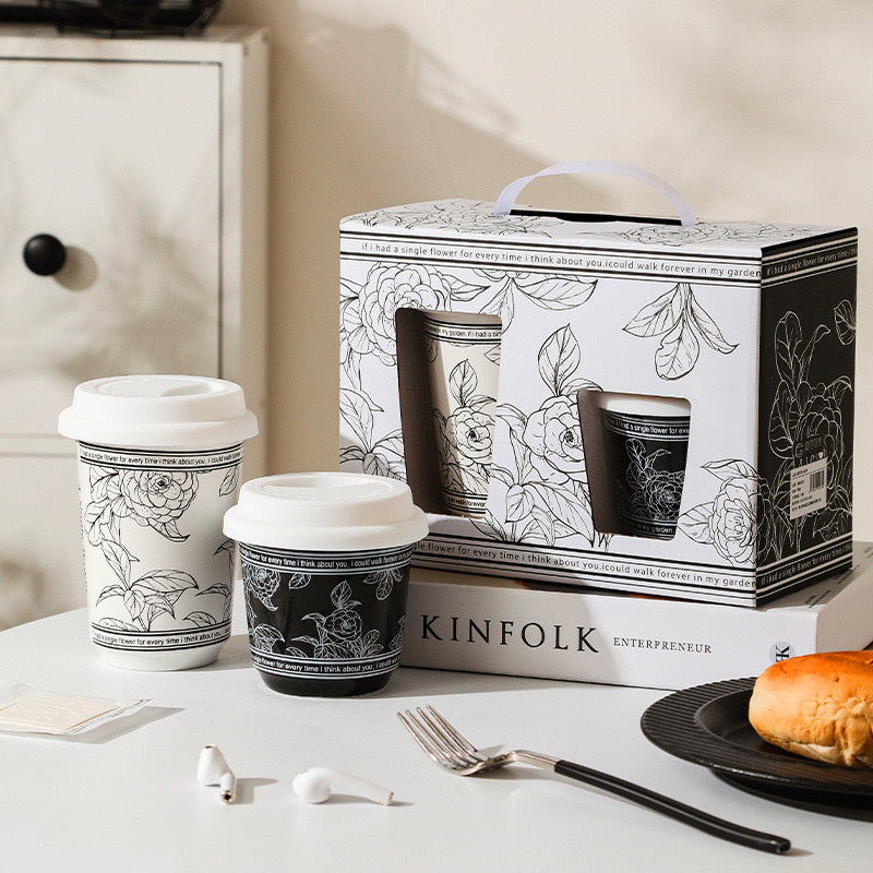 Black and white floral-patterned coffee cups with a Kinfolk box on a table.