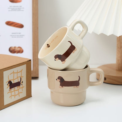 wo stackable ceramic mugs with a dachshund illustration, placed on a white surface with a cozy aesthetic.