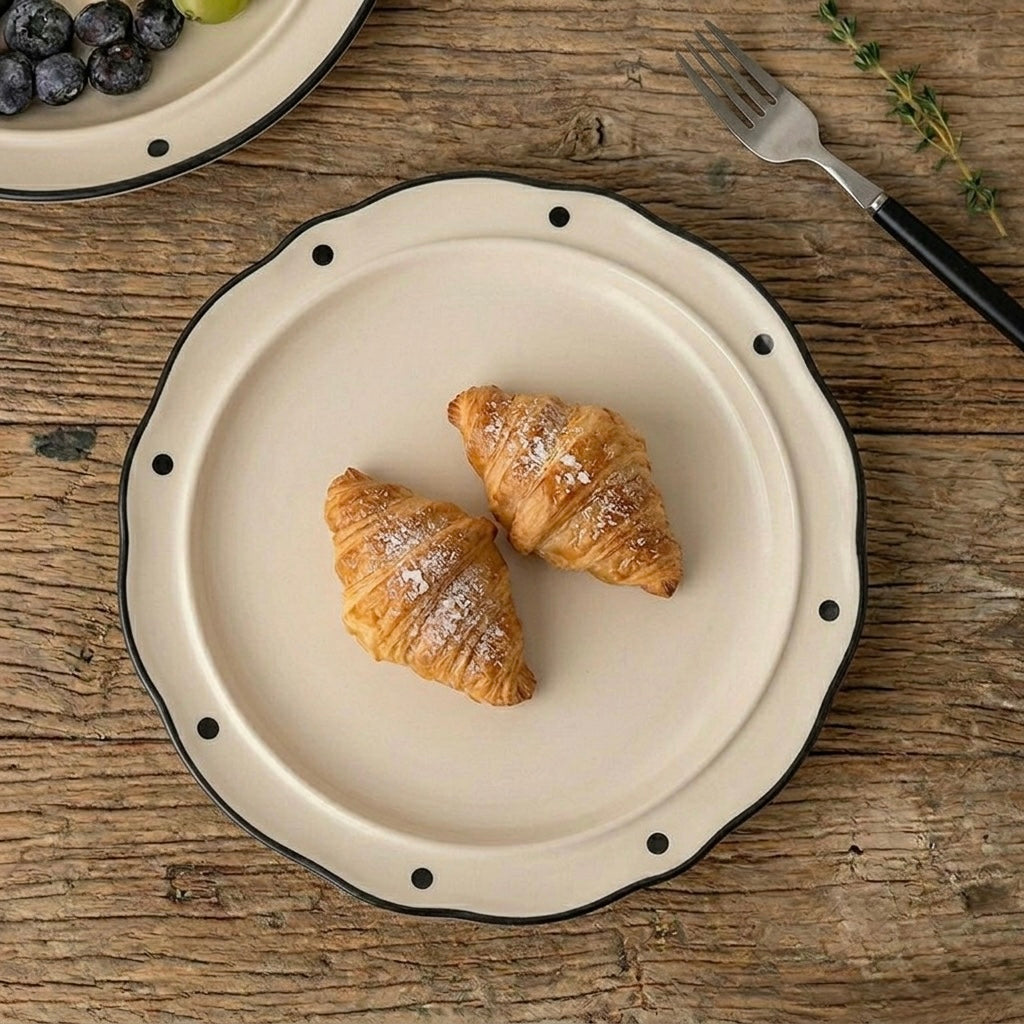 Two croissants on a decorative plate with a wooden background