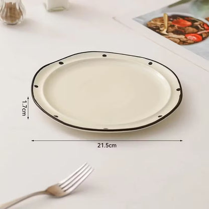 Round ceramic plate with black rim on a white surface, showing dimensions.