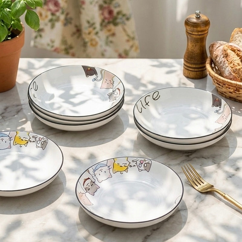Set of ceramic plates with cartoon designs on a marble surface.